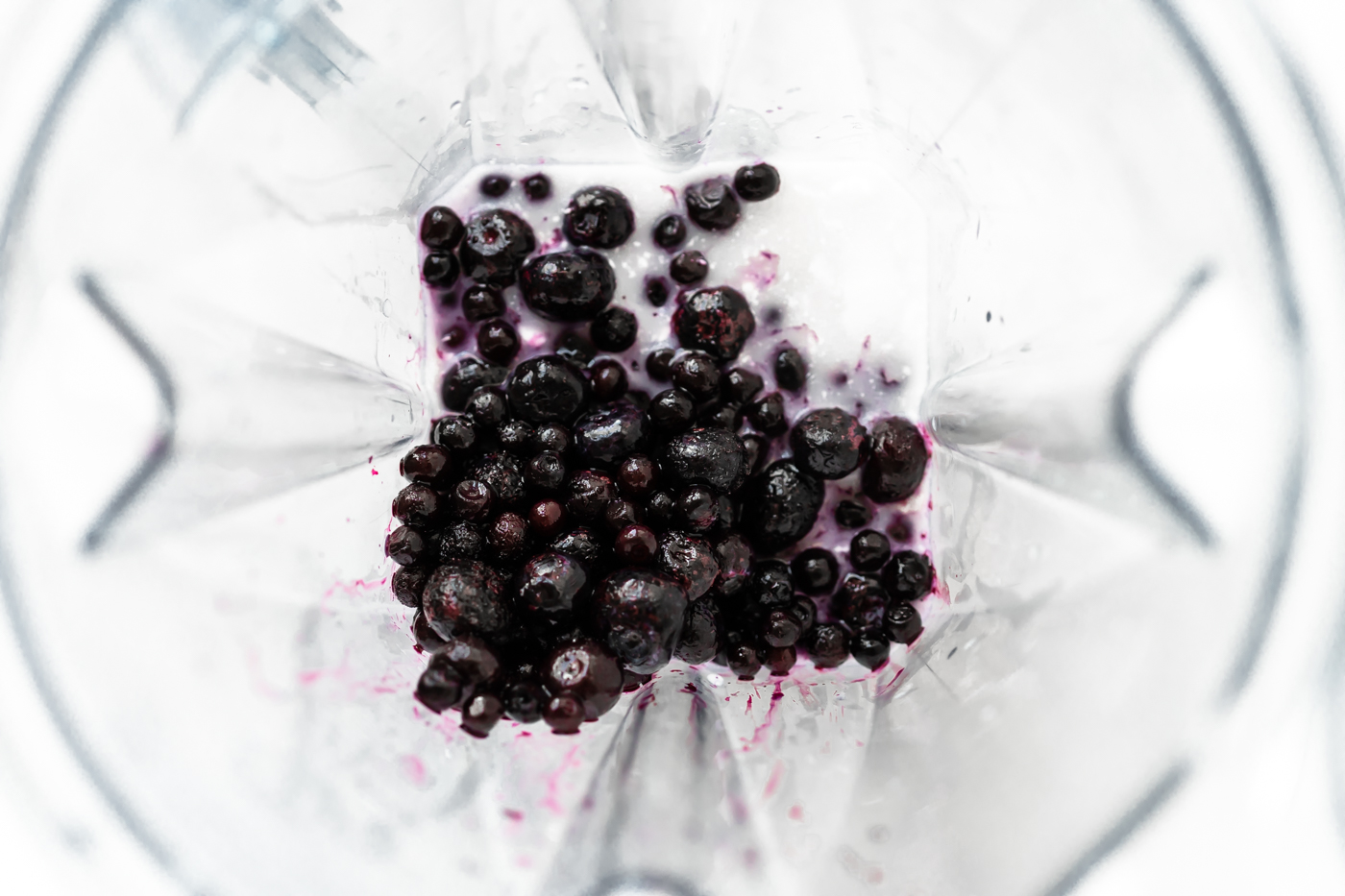Blueberry Coconut Milk Smoothie ingredients inside a blender pitcher. 