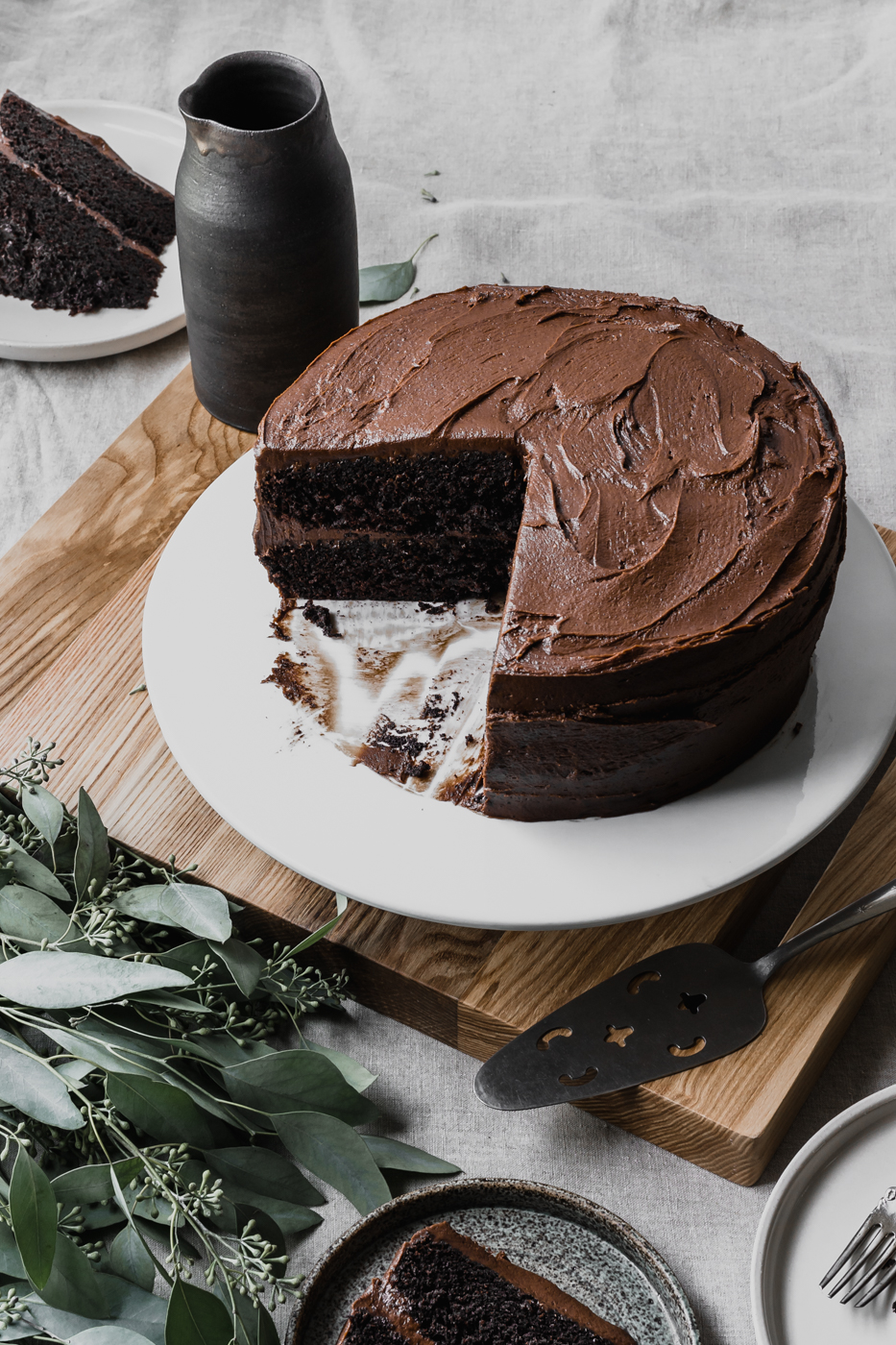 A rich two layer chocolate cake that has been sliced into and is ready to be enjoyed.